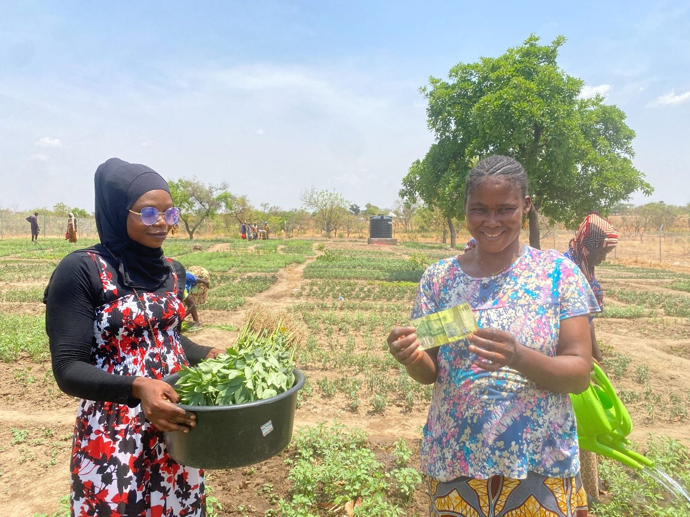 A beneficiary with money from her vegetable sales at the Tarikom garden